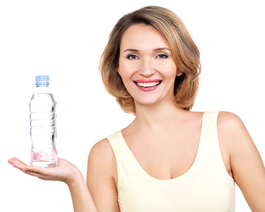 朋友美丽的年轻微笑的女人 白墙上挂着一瓶水液体积极营养