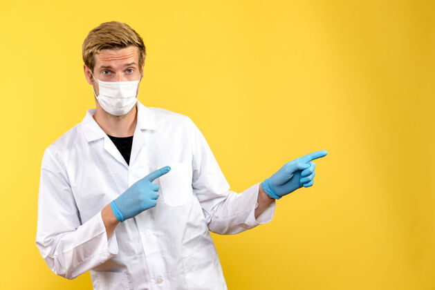 医生正面图黄色背景上的男医生大流行健康冠状病毒观点工作专业