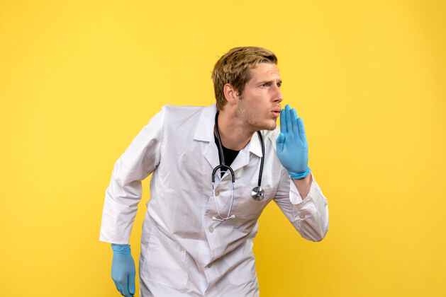 肖像前视图男性医生正在与黄色背景上的人交谈健康医疗人类病毒帅哥前面人