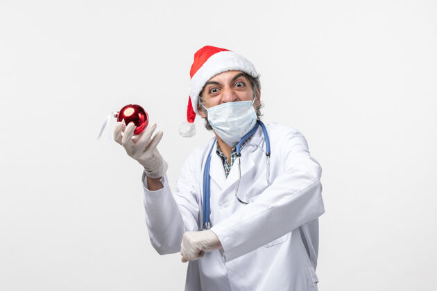 病毒正面图白色地板上戴着玩具面具的男医生健康假日病毒制服医生外套
