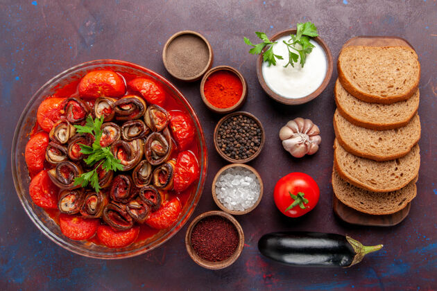 面包顶视图熟蔬菜餐番茄和茄子与调味品和面包在黑暗的桌子上容器桌子胡椒