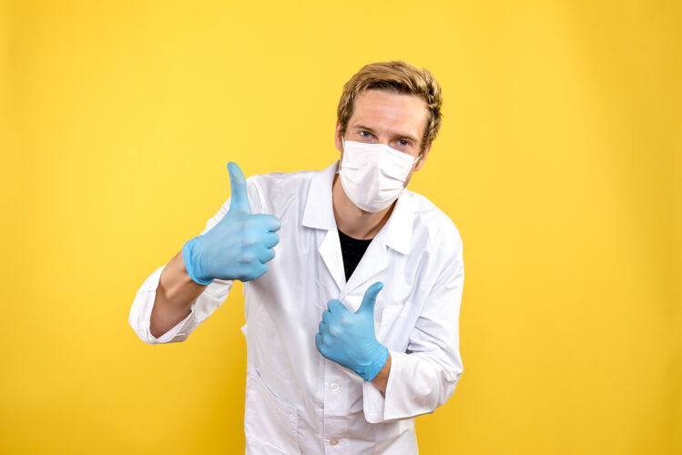 面具正面图黄色背景上戴着面具微笑的男医生大流行医疗科维德-男性医生实验室外套专业