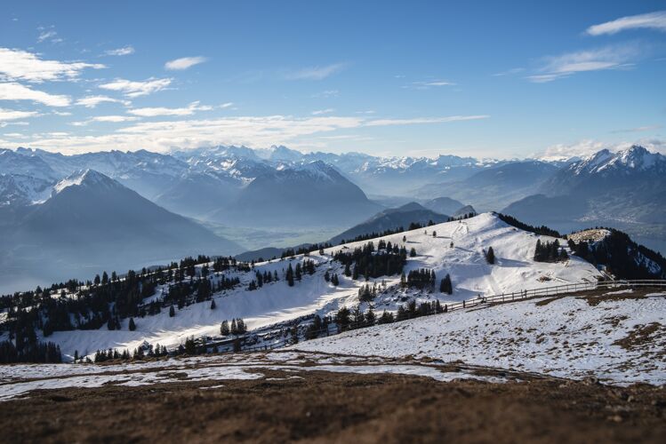 蓝色瑞士大地上的瑞吉山脉的全景照片 在冬天的蓝天下绿色高山雪
