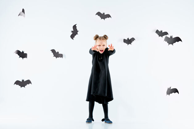 姿势穿着黑色长裙和魔法饰品的小女巫衣服黑色幽灵