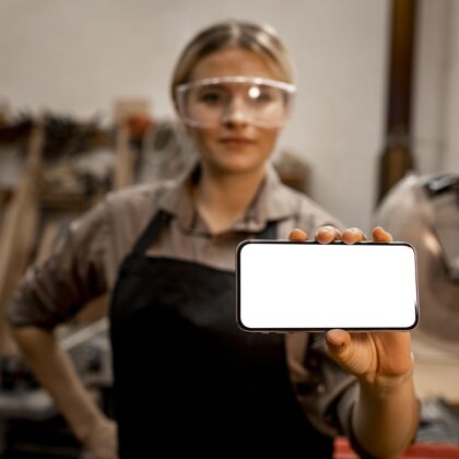 劳动者戴着眼镜拿着智能手机的女木匠职业女人工作