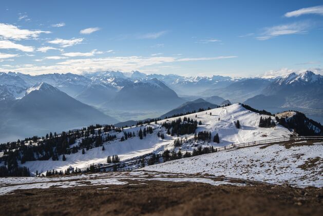 蓝色瑞士大地上的瑞吉山脉的全景照片 在冬天的蓝天下绿色高山雪