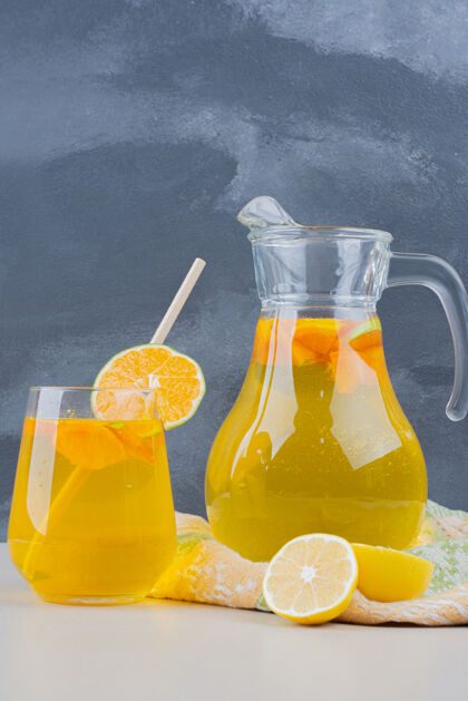 果汁在蓝色的墙上放一杯柠檬水和柠檬片水果冰吸管