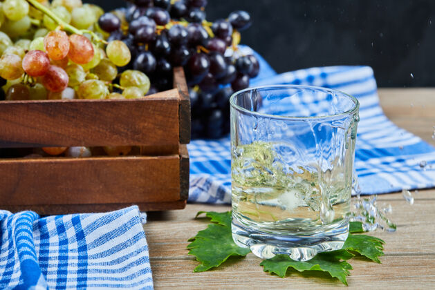 酒一杯白葡萄酒放在木桌上 上面放着葡萄活动酒吧红