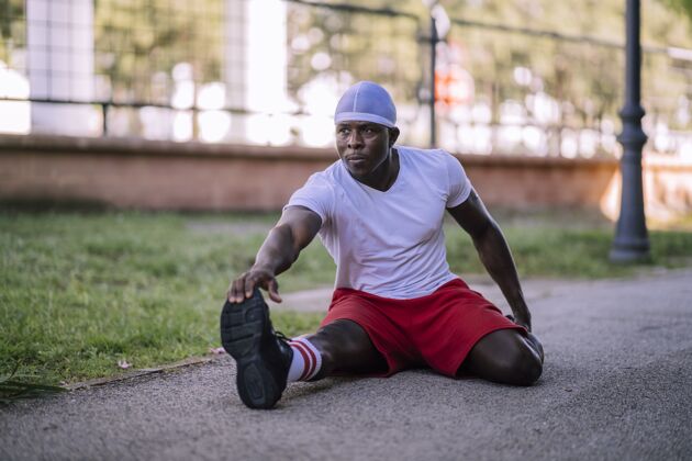 模糊一个穿着白衬衫的非洲裔美国男子在公园伸展的浅焦镜头健康平衡健康
