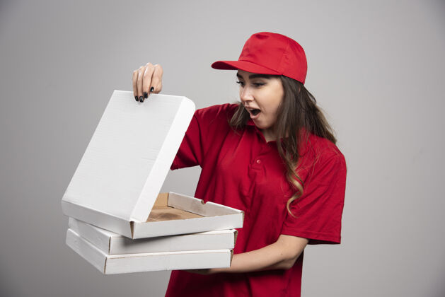 惊喜女快递员看着空比萨饼盒表情女人披萨