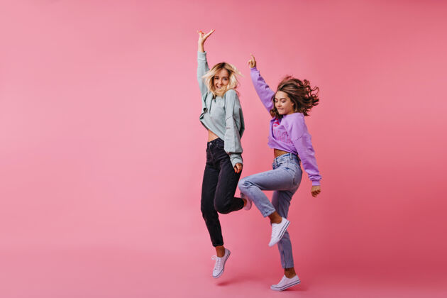 时尚跳跃的白人女孩表达快乐情绪的全长肖像最好的朋友一起有趣跳舞的肖像女人乐趣女性