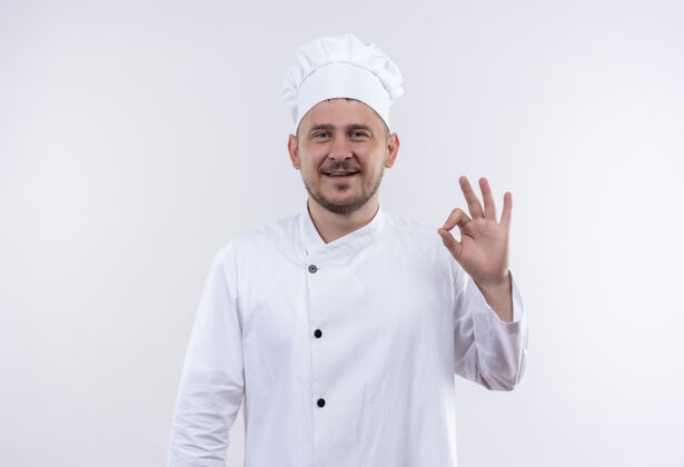 做面带微笑的年轻帅哥厨师身着厨师制服 在空白处做ok标志年轻制服签名