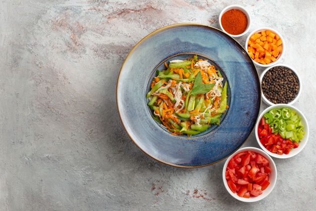 盘子顶视图切菜沙拉与调味品在白色背景午餐菜肴食物