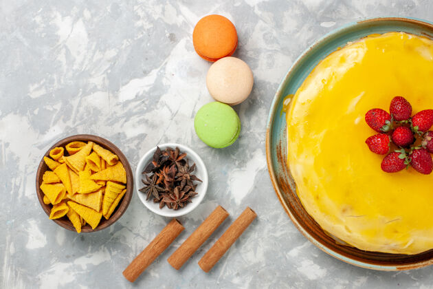饼干顶视图黄色糖浆蛋糕与法国马卡龙在白色背景烘焙麦卡龙食物