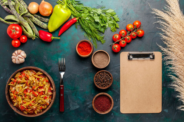 菜在深蓝色背景上 用不同的配料和调味料制作的蔬菜切片 俯视图不同晚餐洋葱