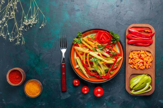 辣椒顶视图切片甜椒美味健康沙拉与调味品和其他蔬菜在黑暗的背景配料背景切片
