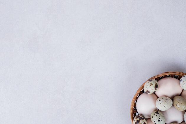 视图鹌鹑蛋和鸡蛋放在白色的碗里顶部视图有机产品