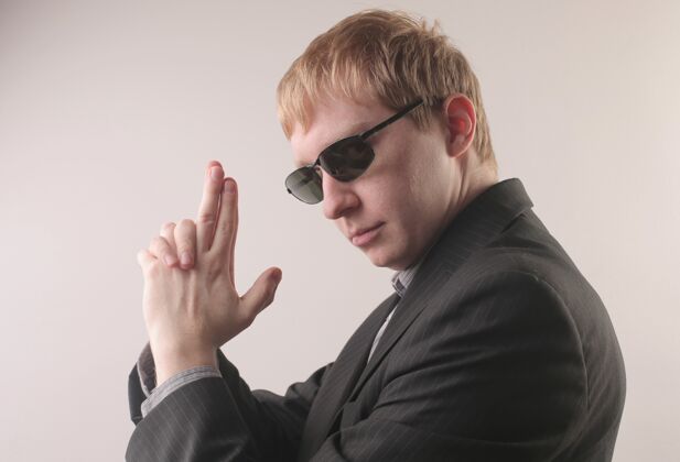 男性一个男人穿着黑色西装 戴着太阳镜 用手指做着枪的姿势家伙时尚领带