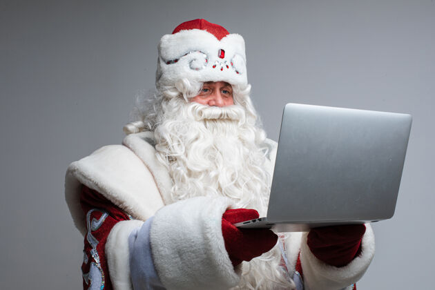 服装带笔记本电脑的圣诞老人笔记本电脑圣诞老人庆祝