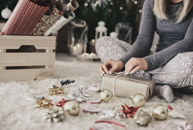 包装人类的手在圣诞礼物上系一根绳子准备手工制作庆祝