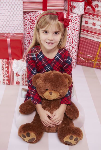 孩子小女孩和她的泰迪熊节日庆祝圣诞礼物