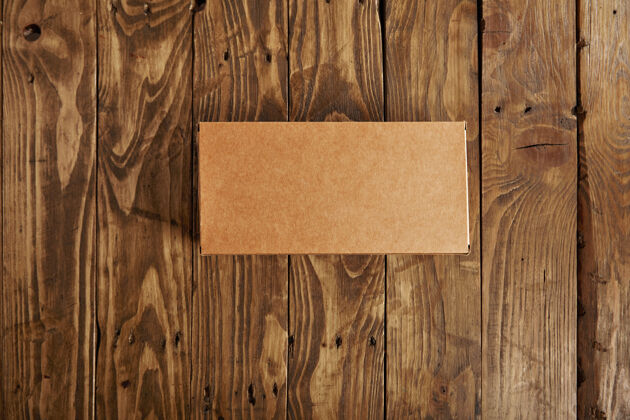 消费主义工艺空白纸板包装盒呈现在强调拉丝木桌上 俯视图仓库把手板