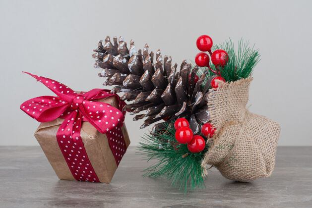 盒子圣诞礼盒和松果放在大理石桌上装饰品圣诞树冬青树