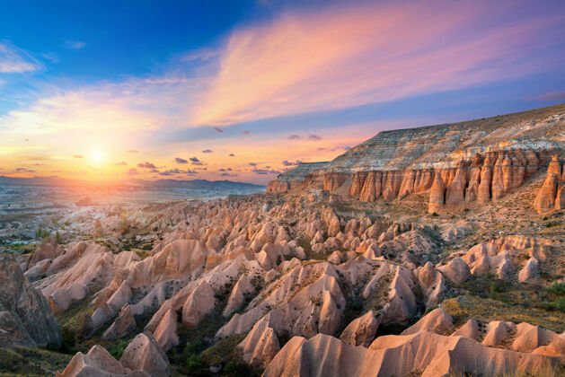 土耳其美丽的山脉和日落时的红色山谷在戈雷姆 卡帕多西亚在土耳其国家日落石头