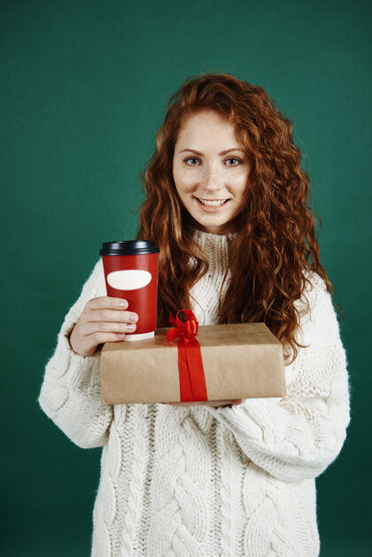 肖像微笑的女人送礼物和咖啡冬天咖啡馆外卖食品