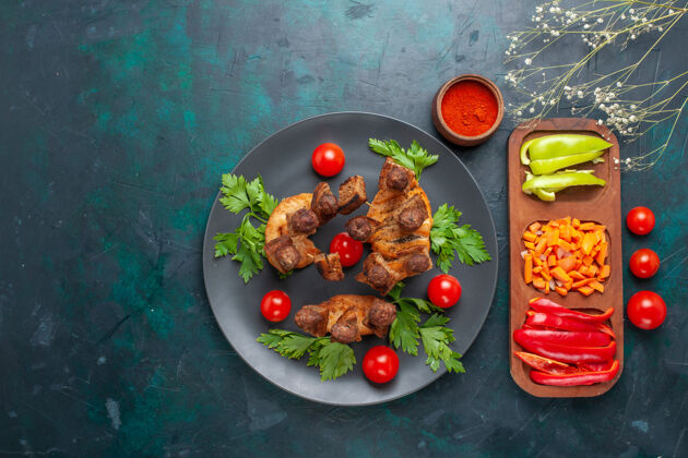 沙拉俯视图：蓝色背景的盘子里放着蔬菜和樱桃西红柿的肉片熟的切片番茄
