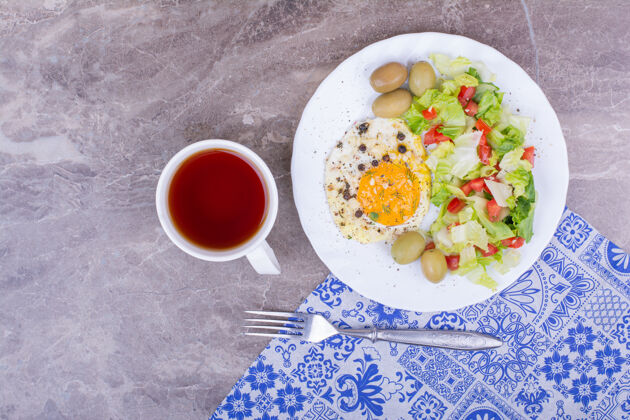 传统煎鸡蛋配蔬菜沙拉和一杯茶新鲜质量膳食
