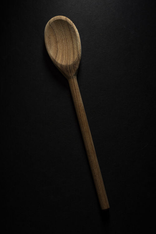 勺子垂直拍摄的一个大木勺孤立的黑色背景天然天然桌子
