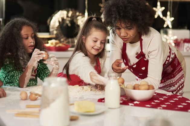 圣诞装饰两个女孩在圣诞节和妈妈做饼干毛衣父母家庭