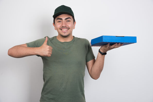 盒子正面信使拿着披萨 在白色背景上竖起大拇指年轻人肖像男人