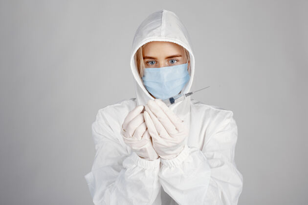 临床戴着医用面罩的医生冠状病毒主题白色背景下隔离穿防护服的女人医生冠状病毒开朗