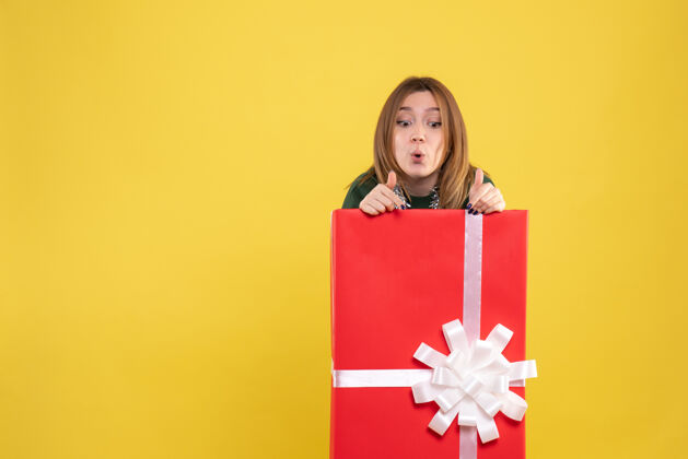 快乐礼物盒内年轻女性的正面图微笑购物者颜色