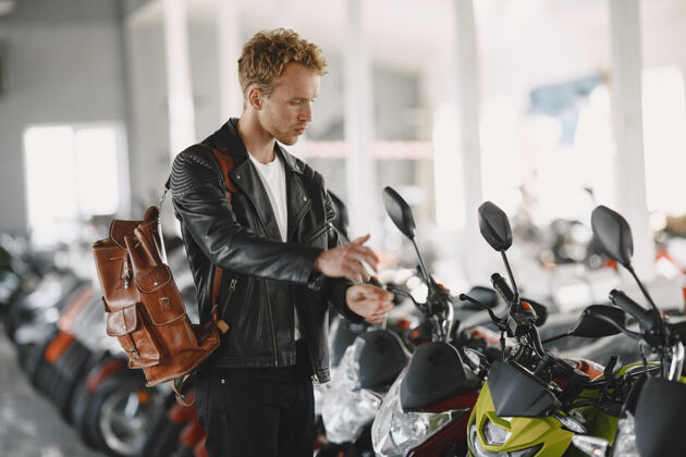 客户一个男人在摩托店里选了摩托车一个穿黑色夹克的家伙摩托车手摩托车选择