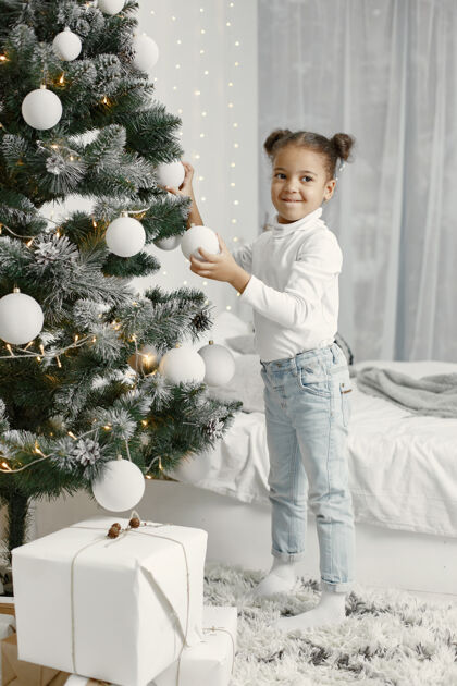 家穿白色毛衣的孩子站在圣诞树旁的女儿人传统女儿