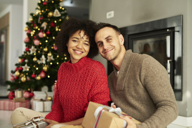 家庭室内一对恩爱的夫妇的肖像为圣诞节做好了准备男人成人幸福