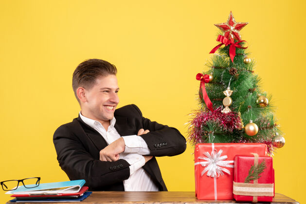 商人正面图：坐在工作台后面微笑的男工人圣诞节笔记本电脑工人