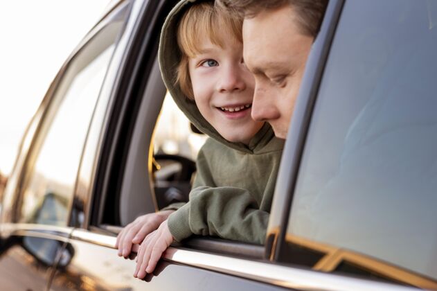 冒险快乐的儿子在车上和爸爸一起公路旅行孩子远足航行