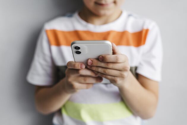 技术前视图模糊的孩子用手机家室内数字