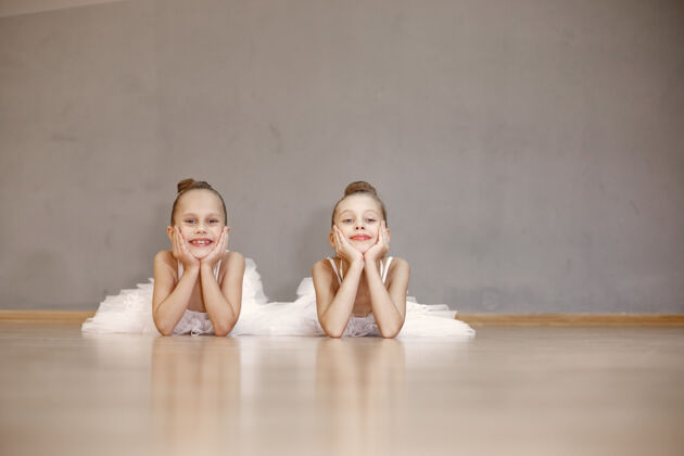 爱好穿着白色芭蕾舞服的可爱的小芭蕾舞演员穿着尖头鞋的孩子们在房间里跳舞舞蹈课上的孩子们芭蕾舞古典排练