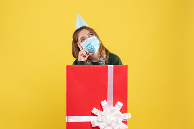 圣诞节正面图无菌口罩内的年轻女性礼品盒生日内部礼物