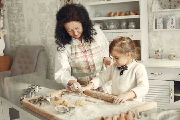 室内厨房里的人奶奶带着小女儿成年妇女教小女孩做饭乐趣女儿奶奶