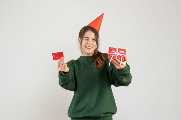 快乐快乐女孩与党帽举行卡和圣诞礼物白色圣诞节人们聚会