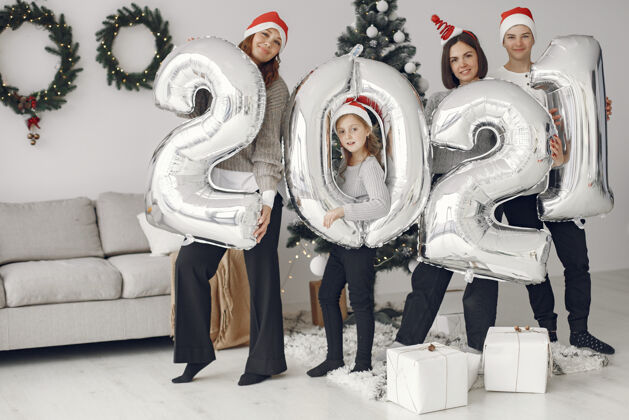 女孩人们在为圣诞节做准备2021年拿着气球的人们\/一家人在节日的房间里休息人阳光孩子