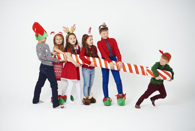 甜蜜顽皮的孩子们拿着大糖果棒圣诞快乐等待手杖