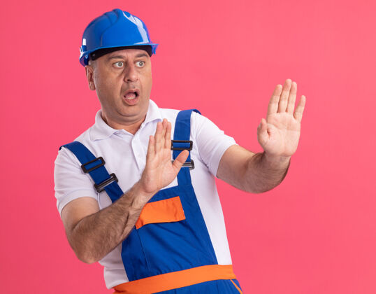 摆姿势焦虑的成年白人建筑工人穿着制服伸出双手孤立手成人工人