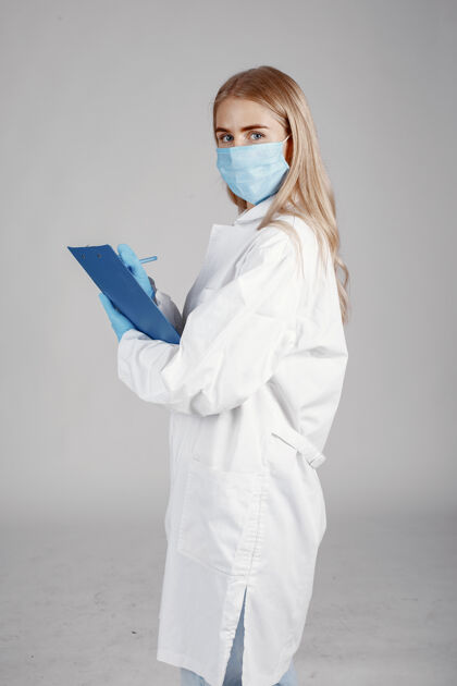 临床戴着医用面罩的医生冠状病毒隔离在白墙上手套文件夹职业